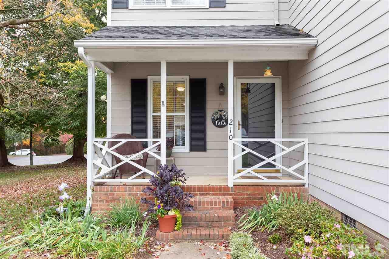 210 Bracken Court Raleigh, NC 27615 - Photo 2 of 26 a view of a house with potted plants and a table and chairs