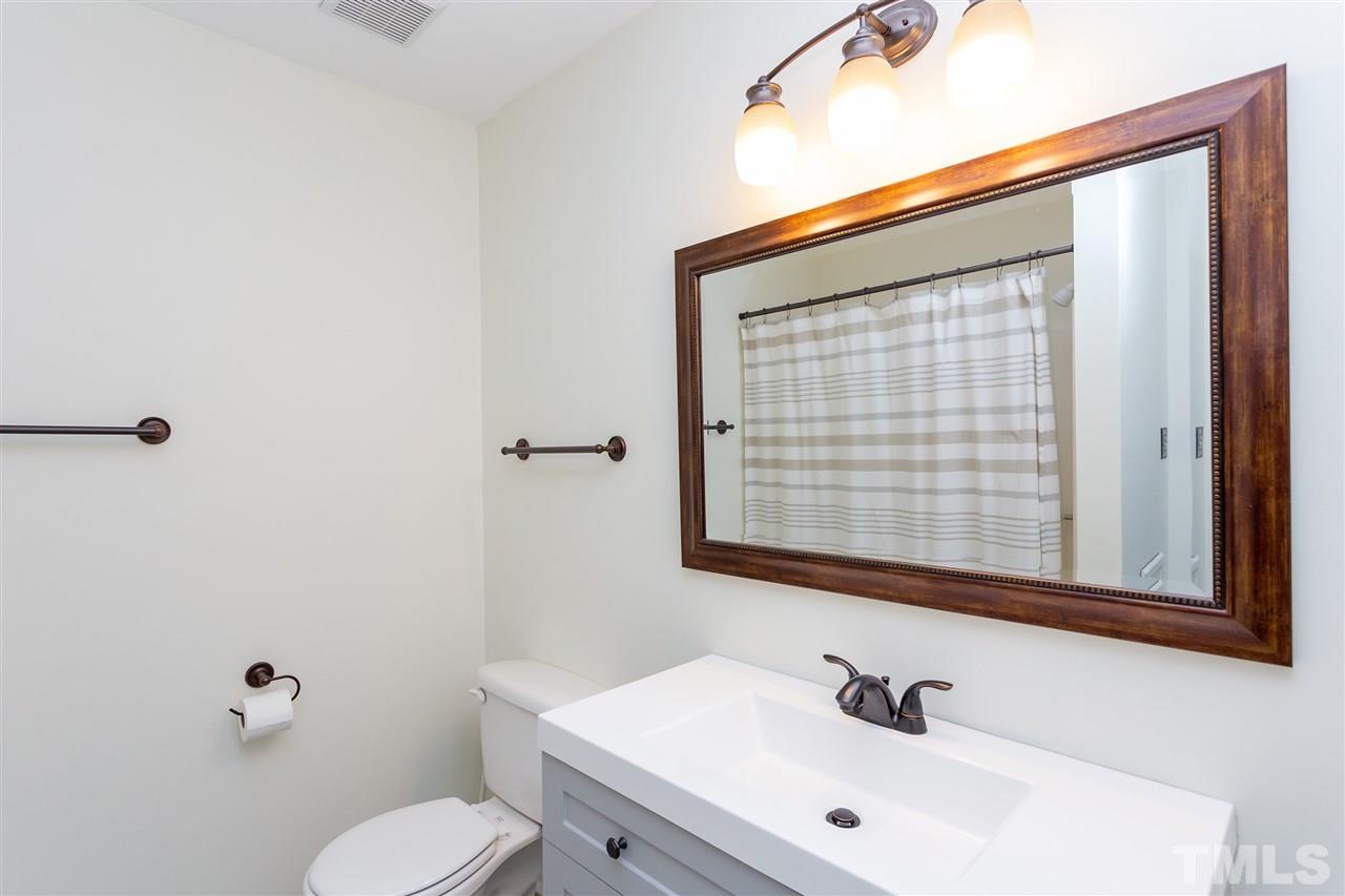 210 Bracken Court Raleigh, NC 27615 - Photo 18 of 26 a bathroom with a sink mirror and toilet