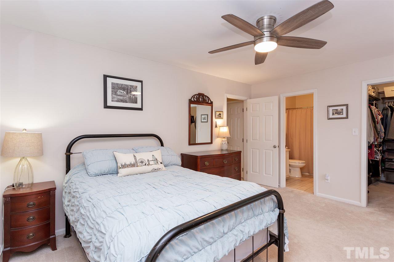 210 Bracken Court Raleigh, NC 27615 - Photo 21 of 26 a bedroom with a bed and a chandelier