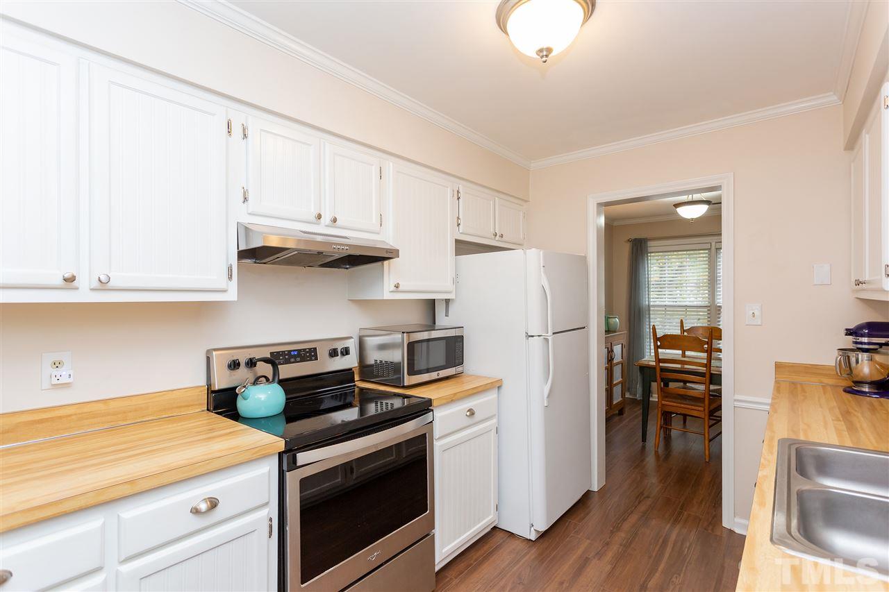 210 Bracken Court Raleigh, NC 27615 - Photo 10 of 26 a kitchen with granite countertop a stove and a refrigerator