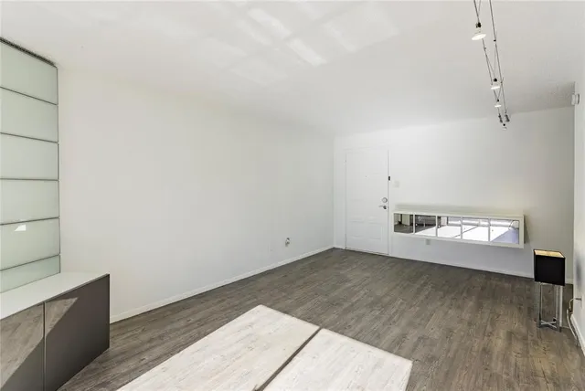 a view of a room with wooden floor and flat screen tv