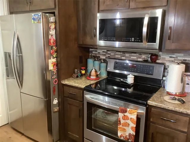 a kitchen with granite countertop a stove and a refrigerator