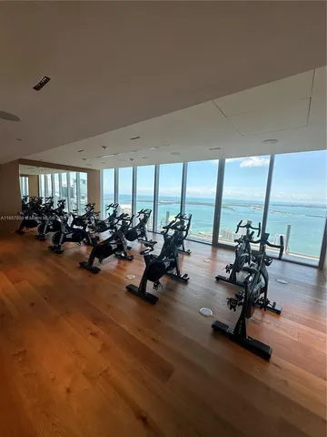 a view of a room with gym equipment and large windows