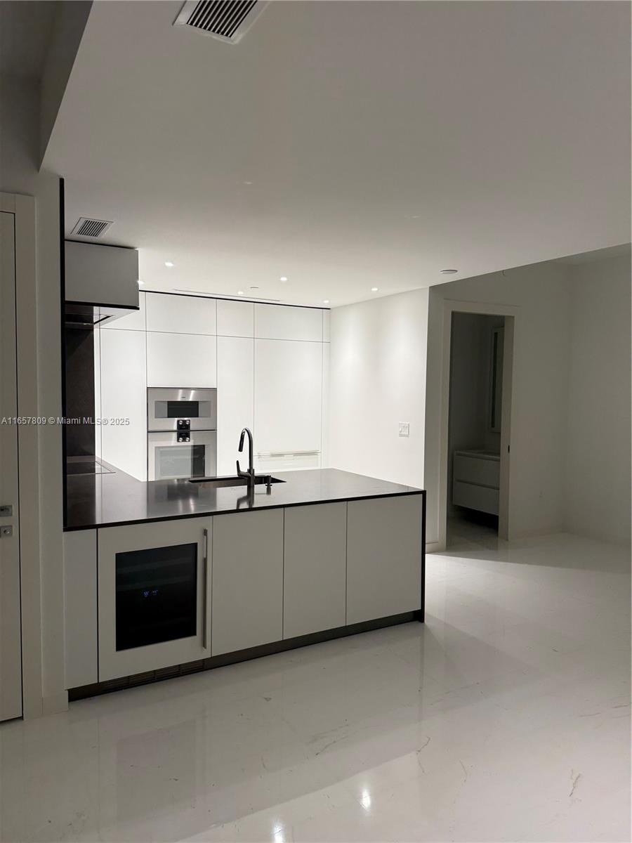 300 Biscayne Blvd Way, Unit 1909 Miami, FL 33131 - Photo 21 of 42 a large white kitchen with a sink and stainless steel appliances