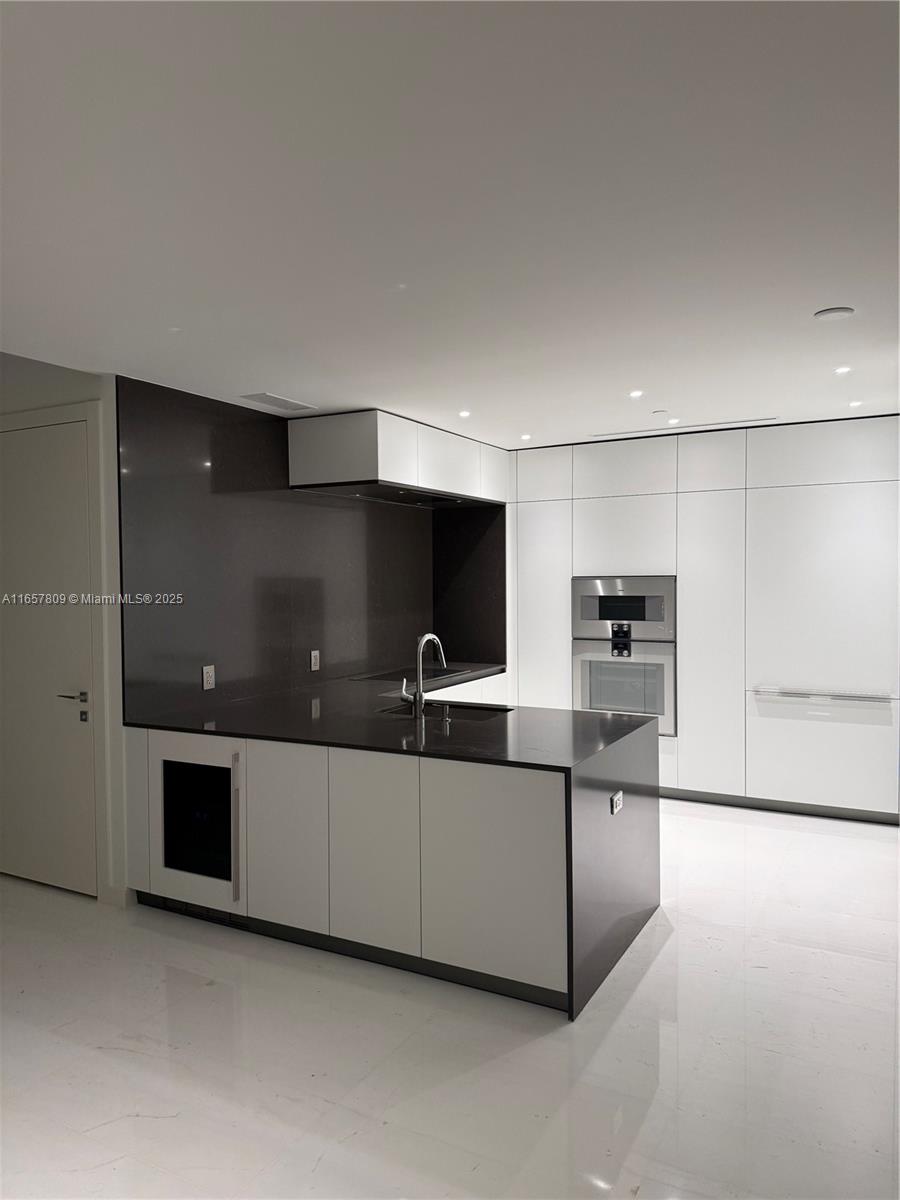 300 Biscayne Blvd Way, Unit 1909 Miami, FL 33131 - Photo 22 of 42 a kitchen with stainless steel appliances kitchen island sink and cabinets