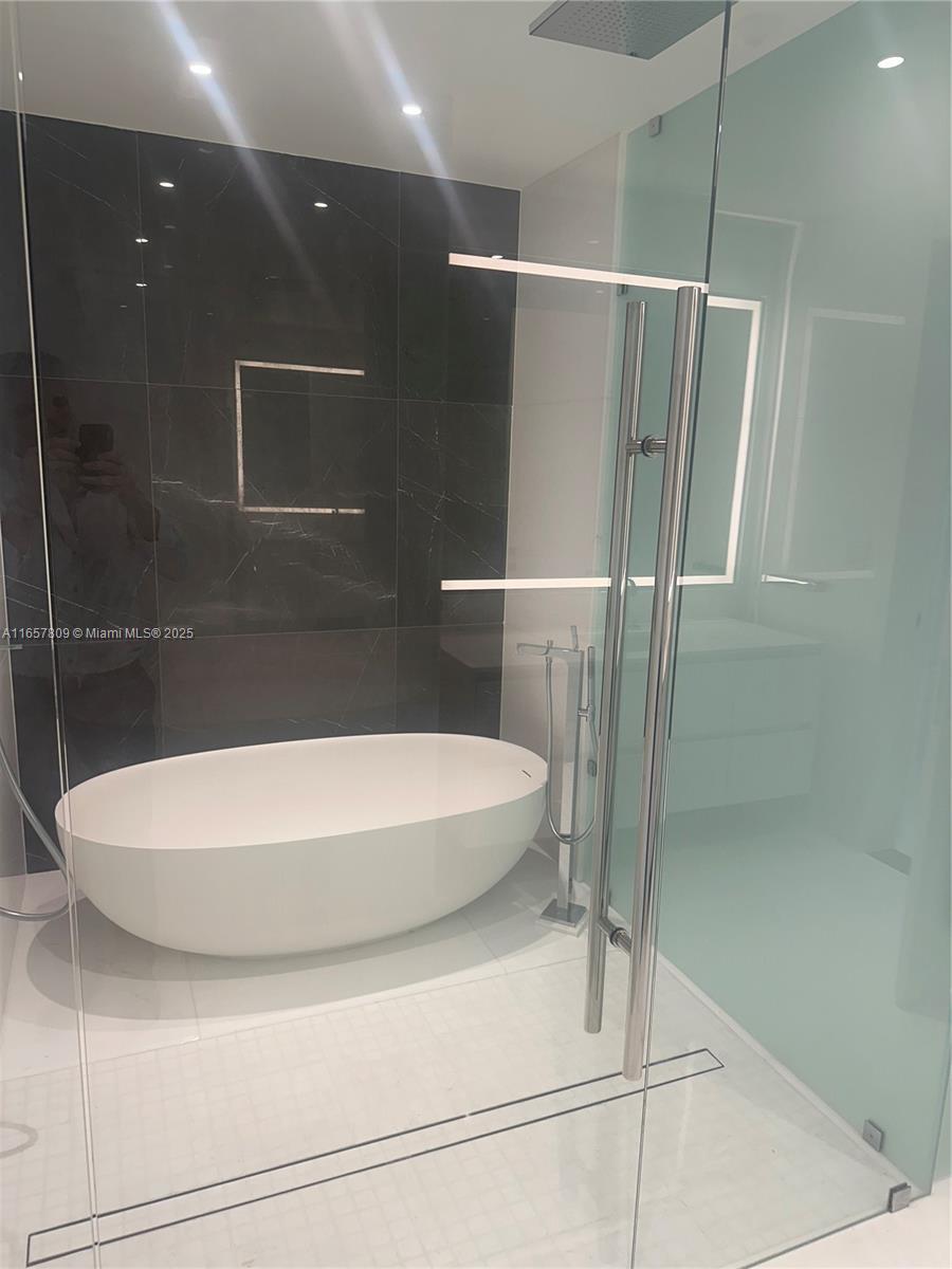 300 Biscayne Blvd Way, Unit 1909 Miami, FL 33131 - Photo 27 of 42 a bathroom with a white bath tub and shower