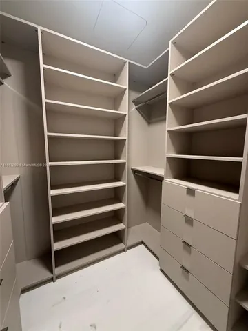 a view of walk in closet with empty racks