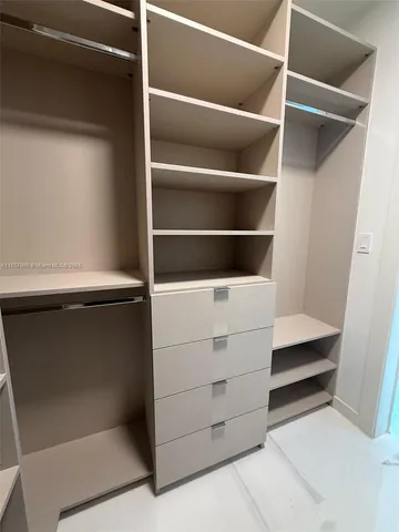 a view of walk in closet with empty racks