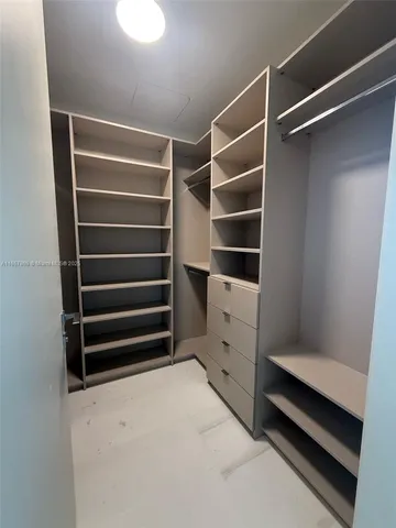 a view of walk in closet with empty racks