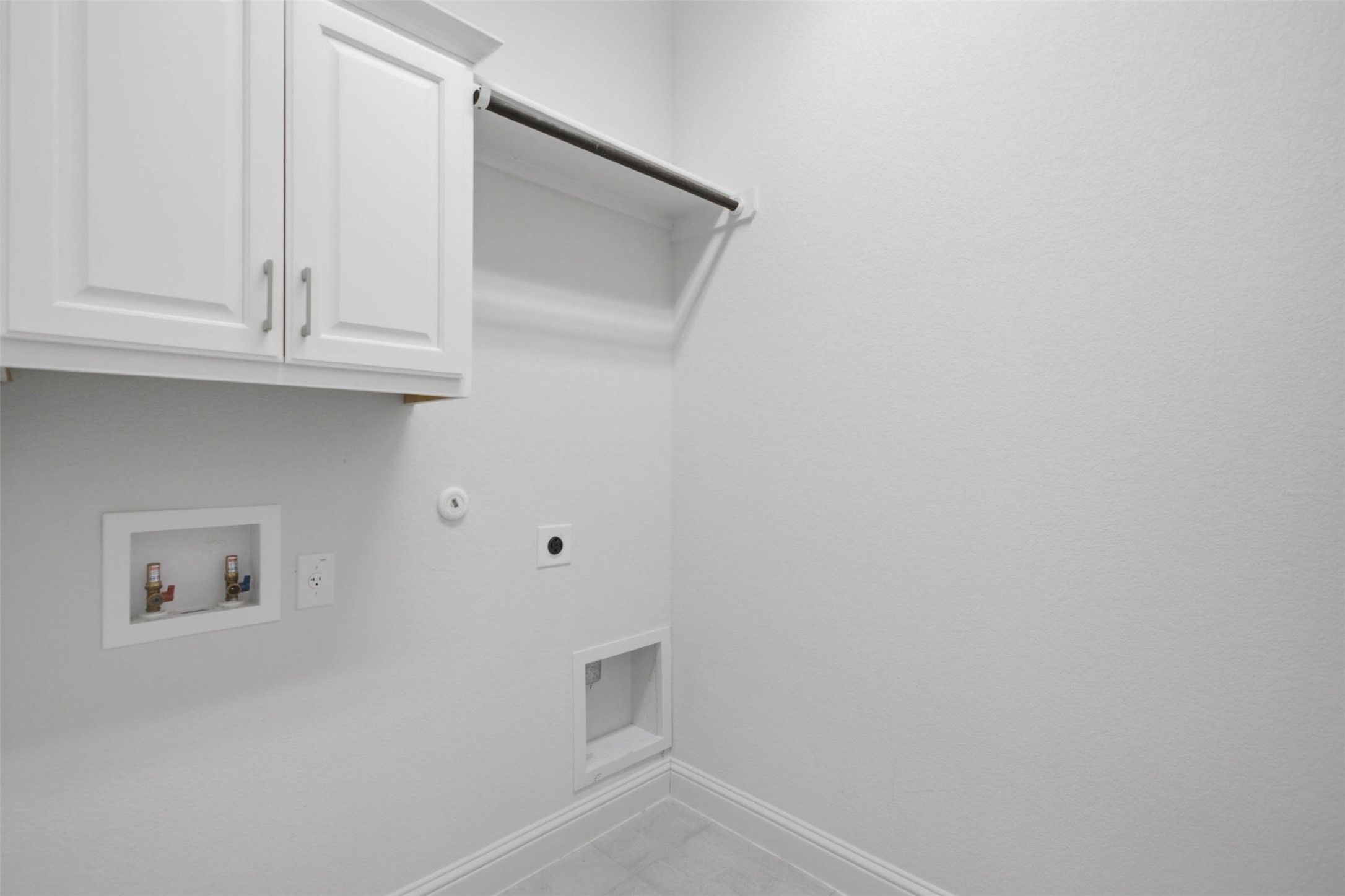 213 Diamondback Drive Georgetown, TX 78628 - Photo 21 of 37 Functional laundry room offers upper cabinetry, a hanging rod, and dedicated hookups for essential appliances.
