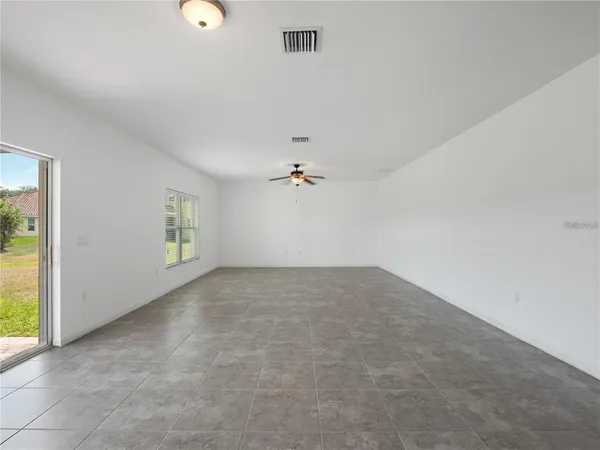 an empty room with a window and a ceiling fan