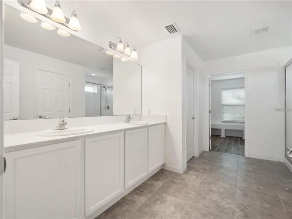 a bathroom with a double vanity sink and a mirror