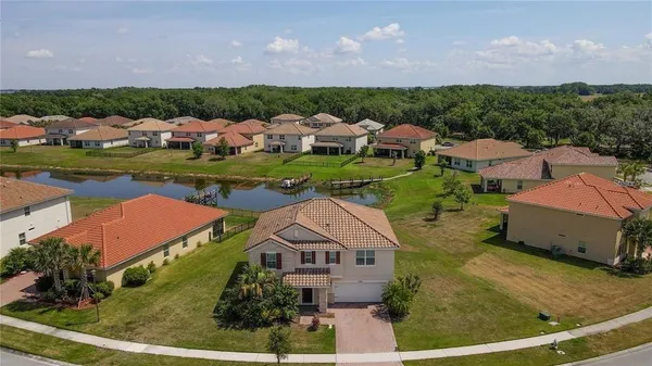 an aerial view of multiple houses with a swimming pool