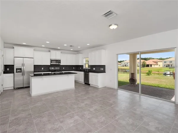 a view of kitchen with refrigerator sink and stove with wooden floor