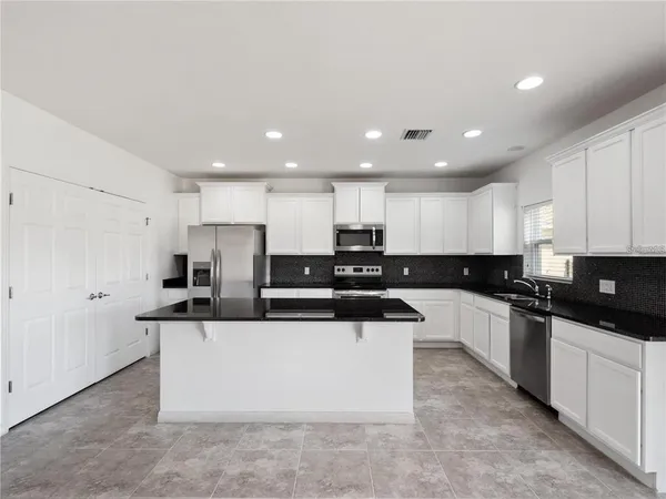 a large kitchen with stainless steel appliances and a sink