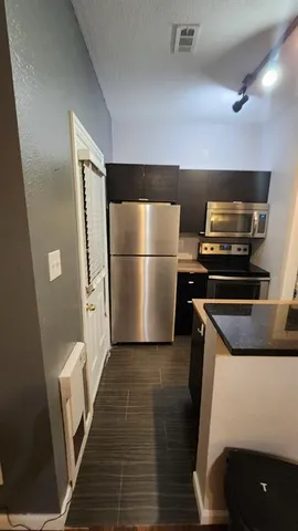 a kitchen with a refrigerator and a stove