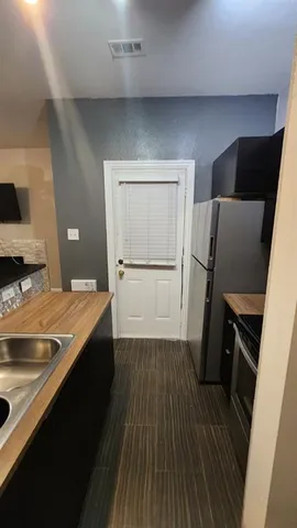 a view of a kitchen with wooden floor and electronic appliances