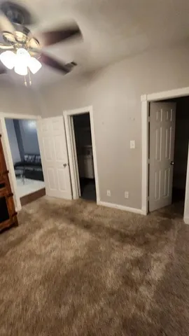 en empty room with windows and ceiling fan