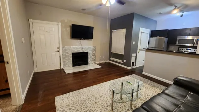 a living room with furniture fireplace and flat screen tv