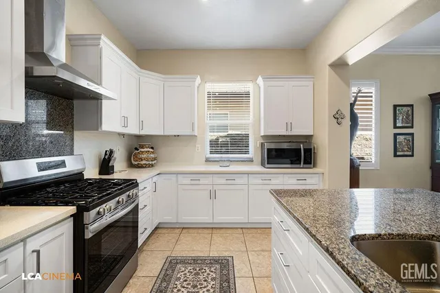 a kitchen with stainless steel appliances granite countertop a stove sink and cabinets