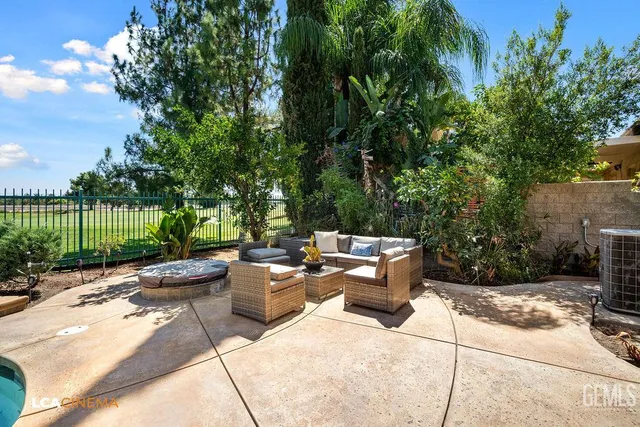 a view of a patio with couches and a table and chairs with wooden fence