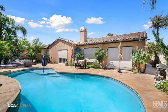 a view of a house with swimming pool and sitting area