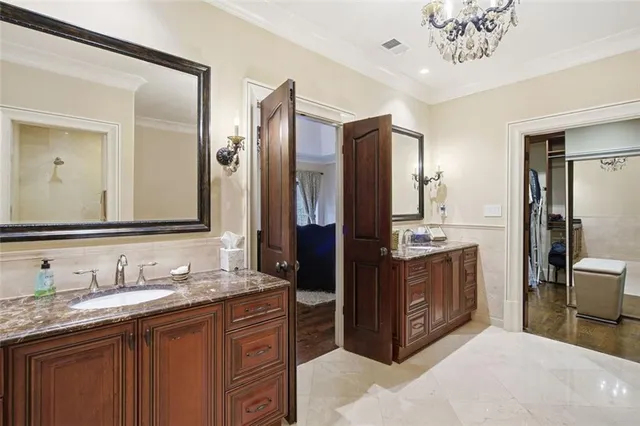 a spacious bathroom with a granite countertop double vanity sink a mirror and a shower