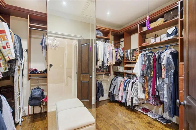 a view of walk in closet with clothes and shoes