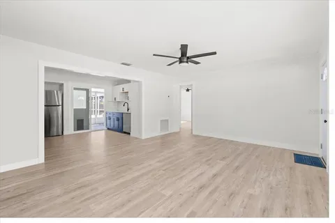 a view of empty room with wooden floor and ceiling fan
