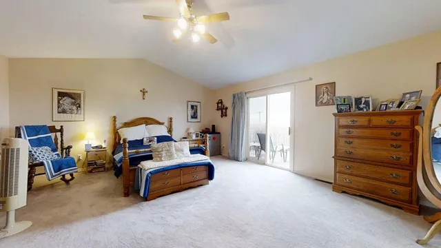 a view of bedroom with furniture and a ceiling fan