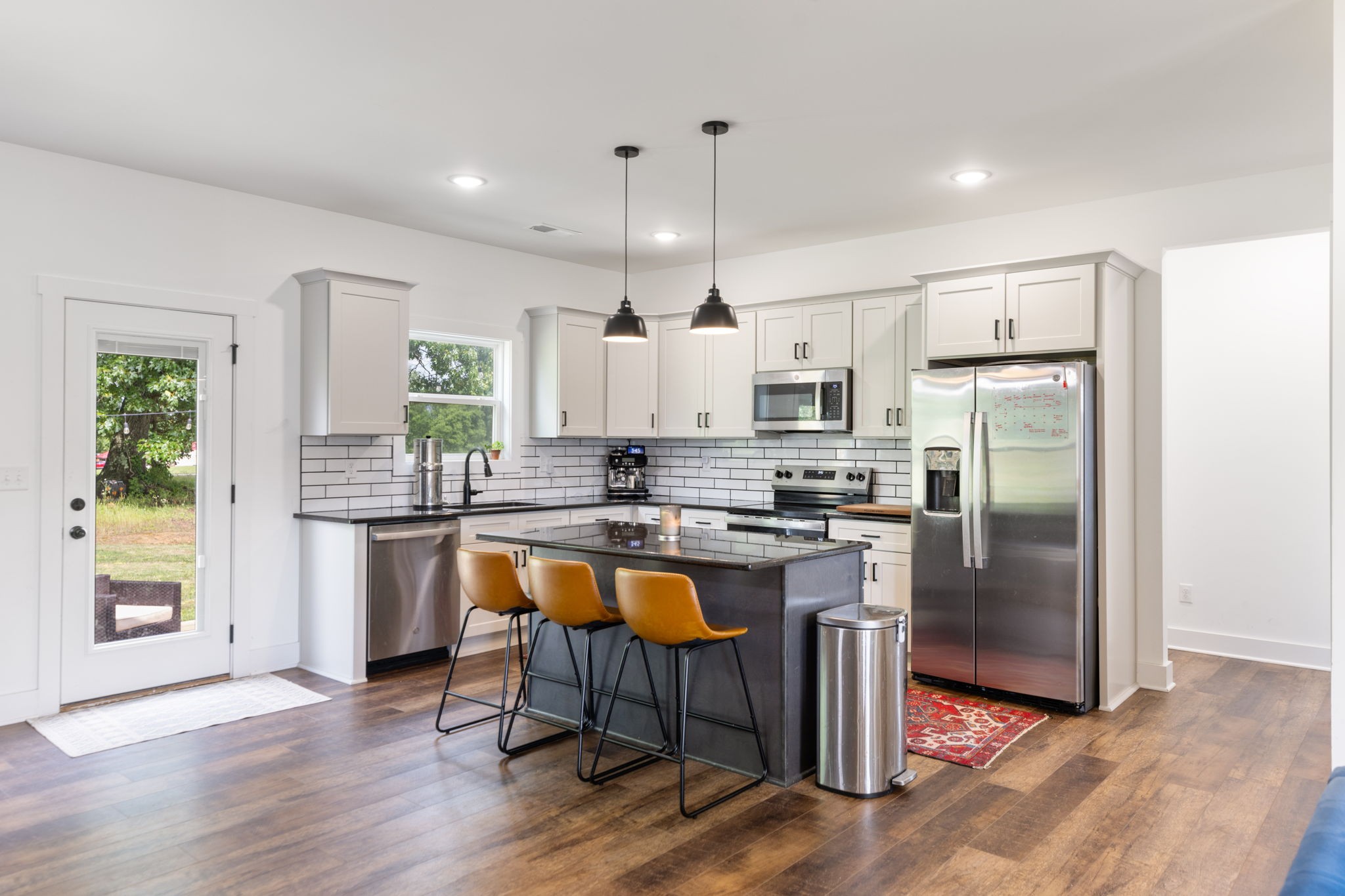 1578 Angus Way Greenbrier, TN 37073 - Photo 15 of 45 a kitchen with stainless steel appliances granite countertop a refrigerator a sink a stove a dining table and chairs with wooden floor