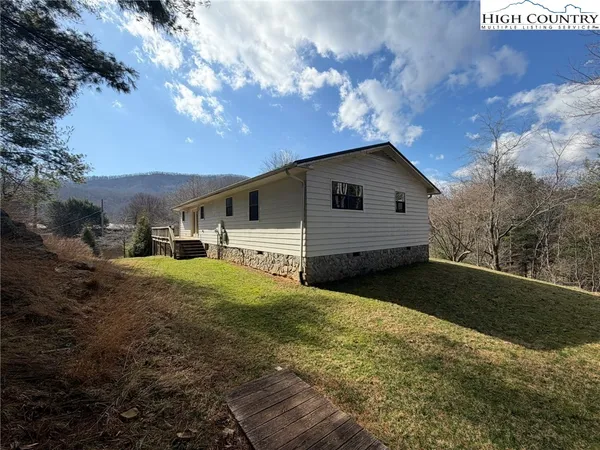 a view of a yard in front of a house with large trees
