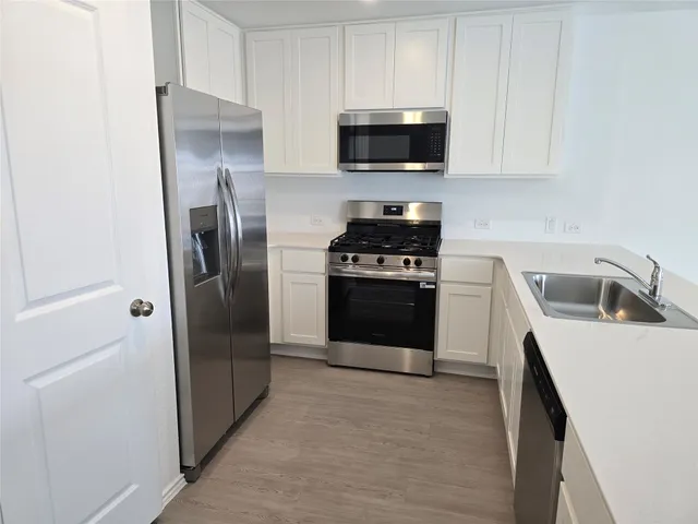a kitchen with stainless steel appliances a refrigerator stove and microwave