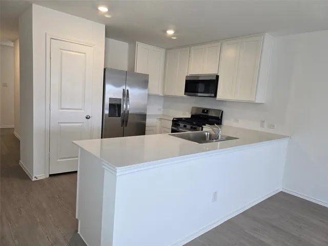 a kitchen with stainless steel appliances a refrigerator sink and microwave