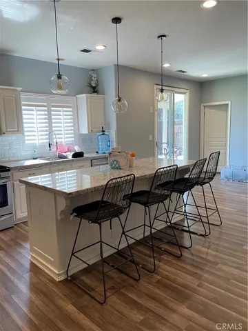 a kitchen with stainless steel appliances granite countertop table chairs stove a sink and dishwasher