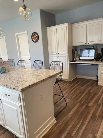 a kitchen with granite countertop a stove a sink and a microwave