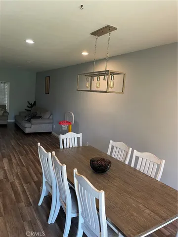 a view of a dining room with furniture a chandelier and wooden floor