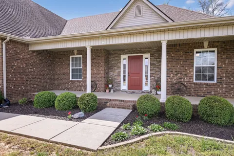 a kitchen with stainless steel appliances granite countertop wooden cabinets a stove top oven a sink and dishwasher with wooden floor