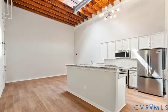 a kitchen with stainless steel appliances a refrigerator and a stove top oven