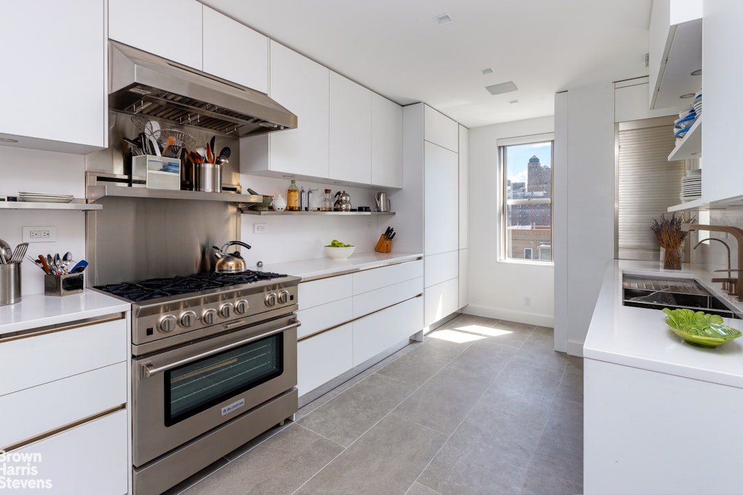 37 Riverside Drive, Unit 12B Manhattan, NY 10023 - Photo 5 of 20 a kitchen with stainless steel appliances granite countertop a stove and cabinets