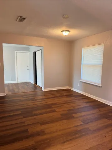a view of a big room with wooden floor and windows