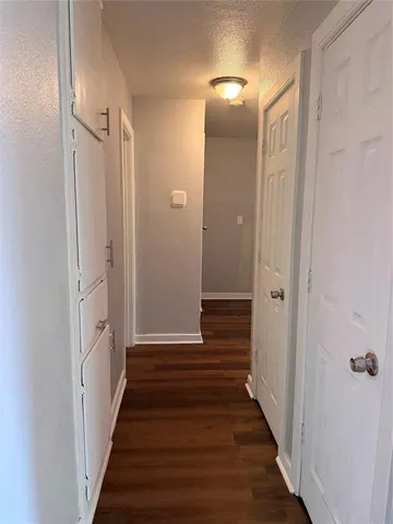 a view of a hallway with wooden floor and stairs