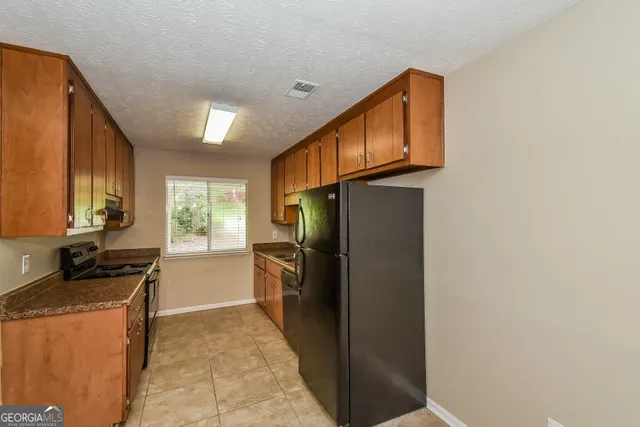 a kitchen with a refrigerator and a stove