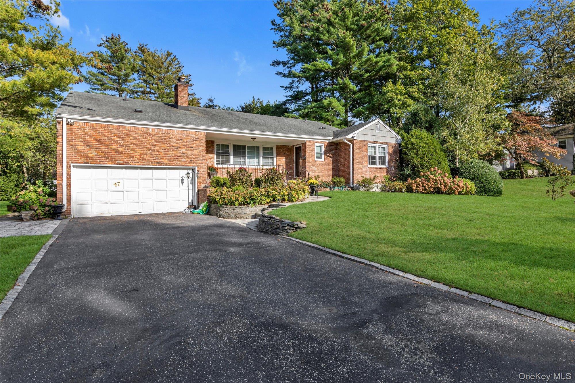 47 Pinewood Road Roslyn, NY 11576 - Photo 22 of 22 a front view of a house with a yard and garage