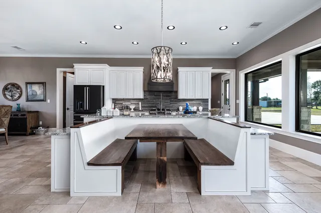 a kitchen with kitchen island granite countertop a stove sink and refrigerator