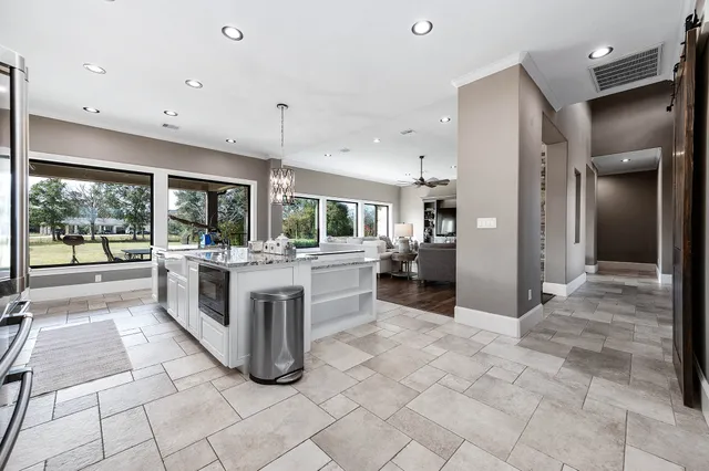 a large kitchen with kitchen island a sink a counter top stainless steel appliances and cabinets