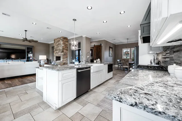 a large kitchen with stainless steel appliances granite countertop a lot of counter space a sink and cabinets