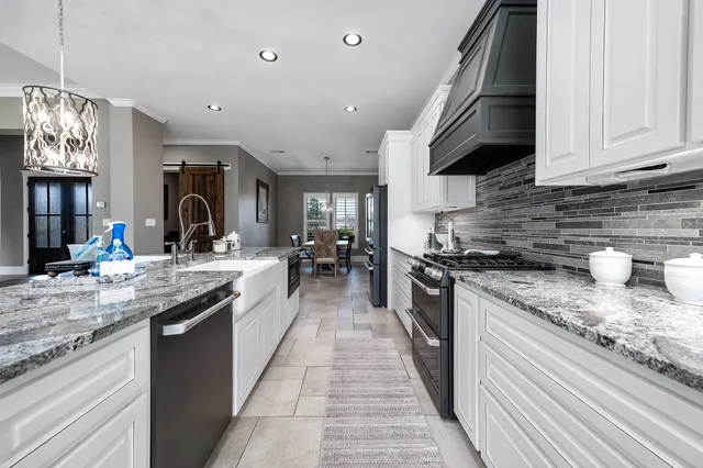 a kitchen with kitchen island granite countertop a sink cabinets and window