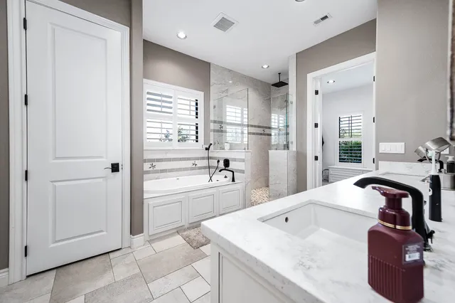 a large bathroom with a double vanity sink a mirror and a bathtub