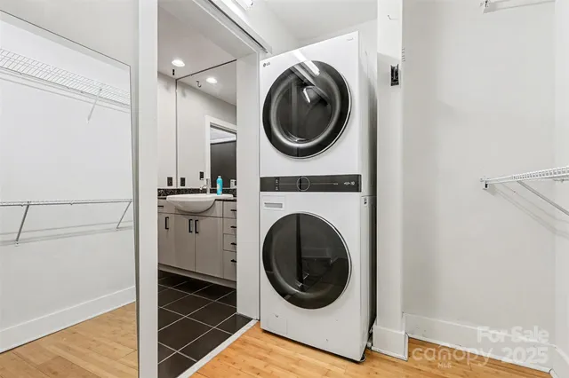 a view of a hallway with wooden floor and a bathroom